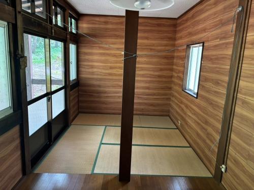 a room with wooden walls and a ceiling with a pole at Yamanomura Campsite - Vacation STAY 88784v in Hida