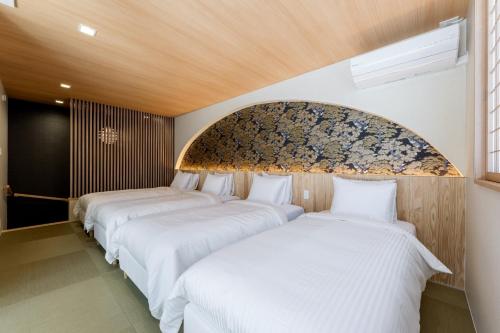 a row of three beds in a room at Oyado michi - Vacation STAY 55924v in Sasebo