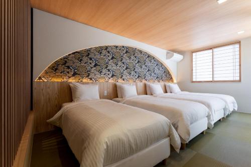a row of three beds in a room at Oyado michi - Vacation STAY 47702v in Sasebo