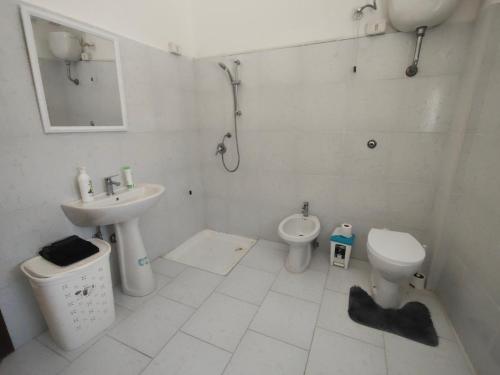 a white bathroom with a sink and a toilet at Alloggio per uso turistico Aldo Lo Presti in Campo di Carne