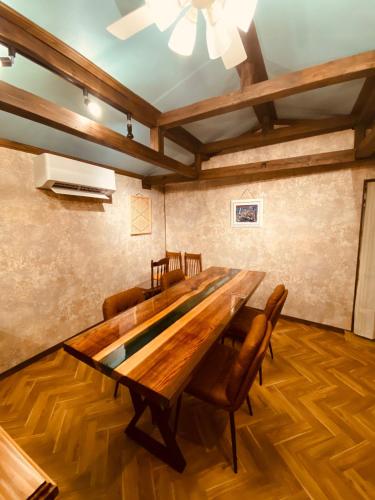a dining room with a wooden table and chairs at Rental of the whole house Amami Yamato-shuku -Akan - Vacation STAY 74831v in Naon