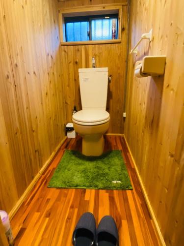 a bathroom with a toilet with a green rug at Rental of the whole house Amami Yamato-shuku -Akan - Vacation STAY 74831v in Naon
