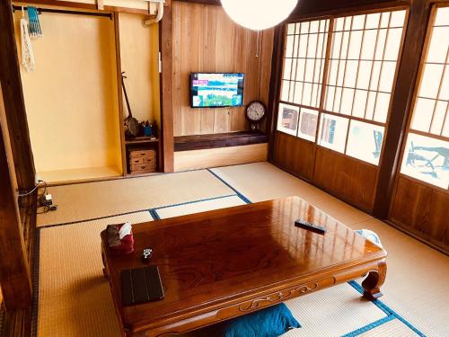 sala de estar con mesa de centro y TV en Rental of the whole house Amami Yamato-shuku -Akan - Vacation STAY 74831v, en Naon