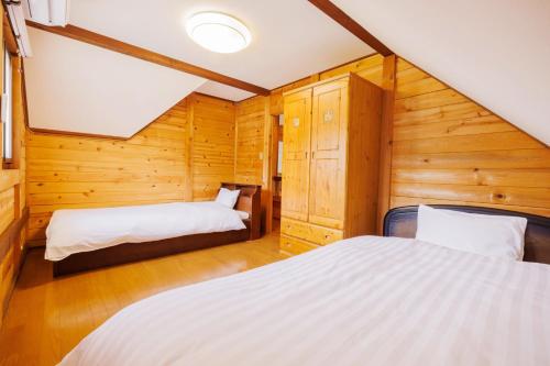 two beds in a room with wooden walls at Pets allowed, natural hot spring rental villa "Yuy - Vacation STAY 54103v in To-katta