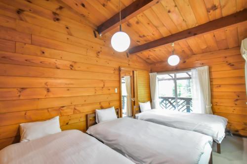 three beds in a room with wooden walls at 410 COZY INN - Rental villa with natural hot sprin - Vacation STAY 54148v in To-katta