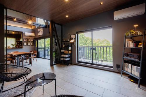 a living room with a table and a balcony at Hot Spring Rental Villa SUMIKA -Sumi- Zao Sansuien - Vacation STAY 54138v in To-katta