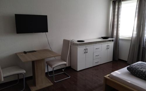 a small room with a desk and a tv on the wall at Monteurwohnung 14 Hoffmann in Heilbronn