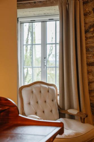 a chair sitting in front of a window at Ecohotel NÓS 