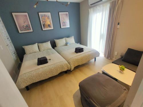 a living room with two beds and a couch at MaMe Inn, - Vacation STAY 80189v in Saitama