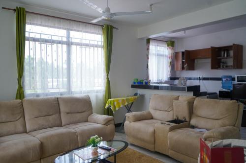 a living room with two couches and a table at S&J Luxury Homes Mombasa in Mombasa