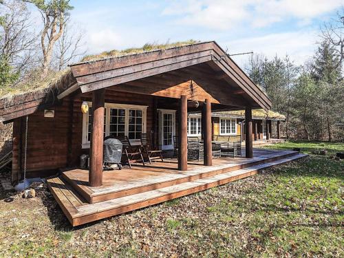 uma pequena cabina com um deque na relva em 8 person holiday home in Frederiksværk-By Traum em Frederiksværk