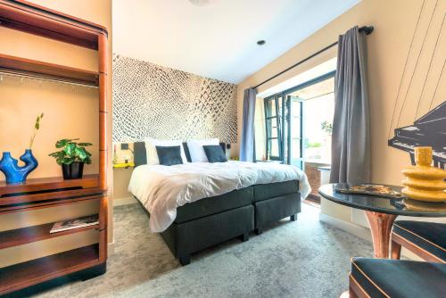 a bedroom with a large bed and a table at Designer Suite in Hotspot Location w Fast Wi-Fi in Tilburg