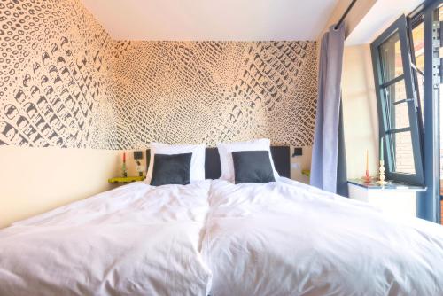 a bedroom with a large white bed with two pillows at Designer Suite in Hotspot Location w Fast Wi-Fi in Tilburg