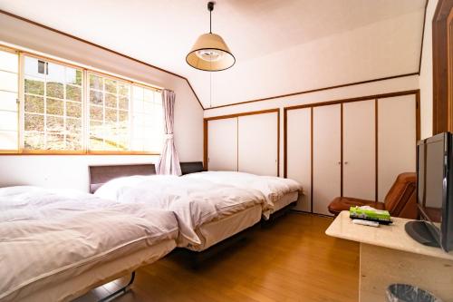 a bedroom with two beds and a tv in it at Kattagun - House - Vacation STAY 17460 in To-katta
