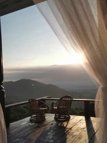 two chairs sitting on a deck with a view of the mountains at 4000Dao- A Hilltop Hideaway & Experience in Doi Tung 