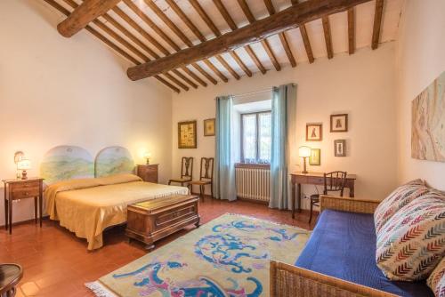 a bedroom with a bed and a blue couch at Tenuta Podere Montemelino in Sarteano