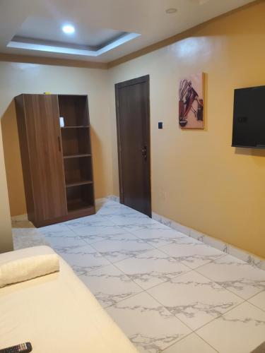 a room with a door and a tv on a wall at Romeo Suites & Apartment in Ipaja