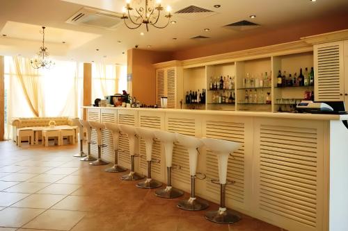 a bar with a row of white bar stools at Marino Mar Deluxe Studios, Sauna Indoorpool Spa & Wellness inclusive in Sunny Beach