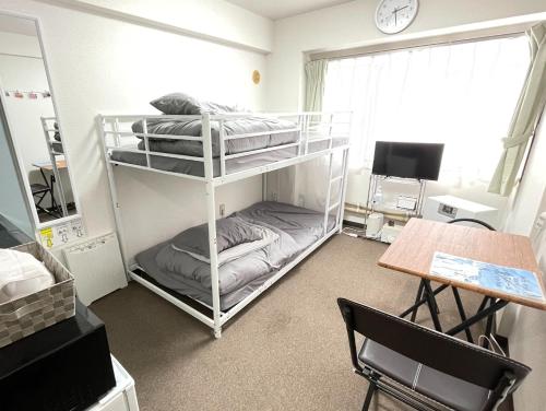 une chambre avec deux lits superposés et une table dans l'établissement Room 305 Aruter Hotel Sapporo 10-minute walk from Sapporo Station Japanese modern room - Vacation STAY 18410, à Sapporo