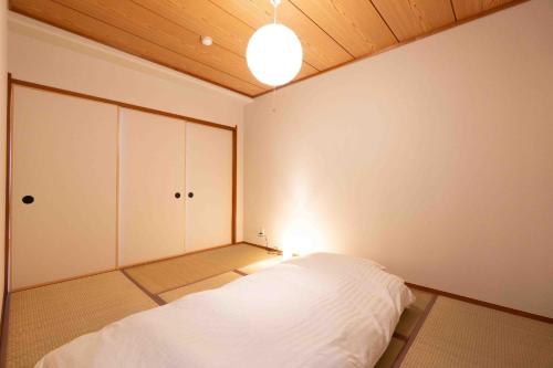 a bedroom with a white bed and a wooden ceiling at Cadoro Ichibankan - Vacation STAY 92586v in Utazu