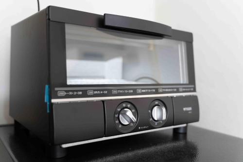 a black microwave oven sitting on top of a table at Cadoro Ichibankan - Vacation STAY 92586v in Utazu