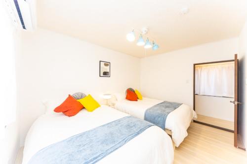 two beds in a room with white walls at Ikkenya - Vacation STAY 17622 in Kuwana