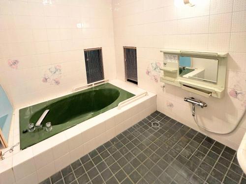 a bathroom with a green tub and a sink at RAKUNTO - Vacation STAY 17633 in Mikage