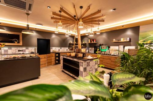 a shop with a large chandelier in a room with plants at WohnGut Koblenz in Koblenz