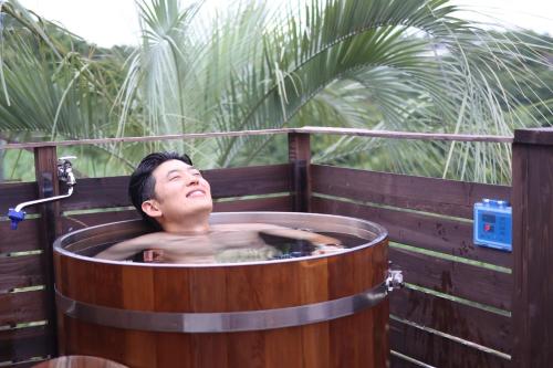 a man sitting in a wooden bath tub at AKESUKE - Vacation STAY 67241v in Minamiawaji