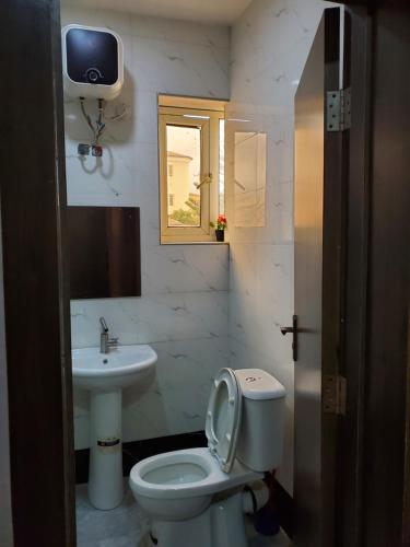a bathroom with a toilet and a sink at Romeo Suites & Apartment in Ipaja