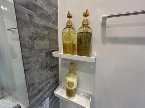 three bottles of wine sitting on shelves in a bathroom at Imizu - House - Vacation STAY 17693 in Imizu
