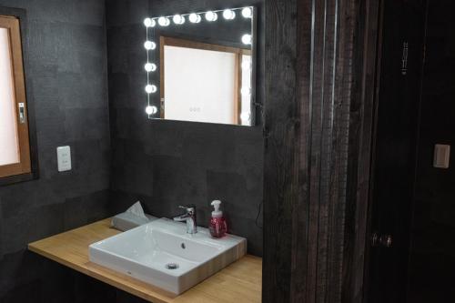 a bathroom with a white sink and a mirror at Machiyado Niko - Vacation STAY 83480v in Kusatsu