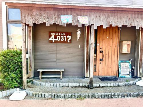 a sign on the door of a house with a bench at Guesthouse EN - Vacation STAY 85401v in Kitakyushu