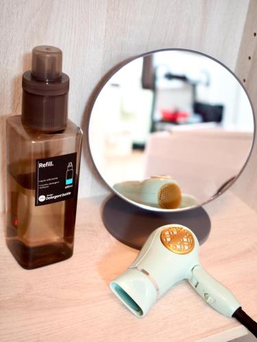 a mirror next to a bottle of soap and a brush at Guesthouse EN - Vacation STAY 85401v in Kitakyushu