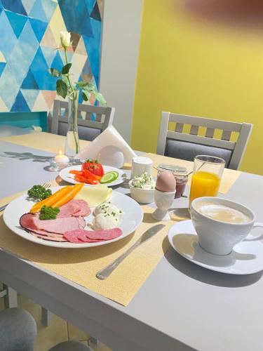 ドロトボにあるHotel Jabłońskiの食べ物と飲み物の盛り合わせが付いたテーブル