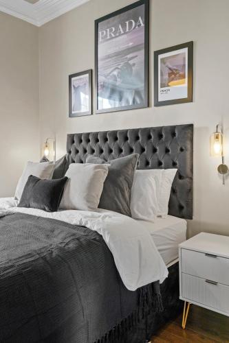 a bedroom with a large bed and two pictures on the wall at Georgian Apartment In Yorkshire - Parking in Wakefield