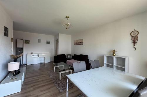 a living room with a table and a couch at Apartment with balconies close to beaches in Caen