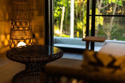 a table and a chair in a room with a window at RYUKYU BREEZE No,1, No,2, No,3, No,4 - Vacation STAY 91466v in Nago