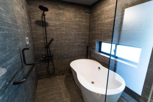 a bathroom with a tub and a sink and a shower at RYUKYU BREEZE No,1, No,2, No,3, No,4 - Vacation STAY 91504v in Nago