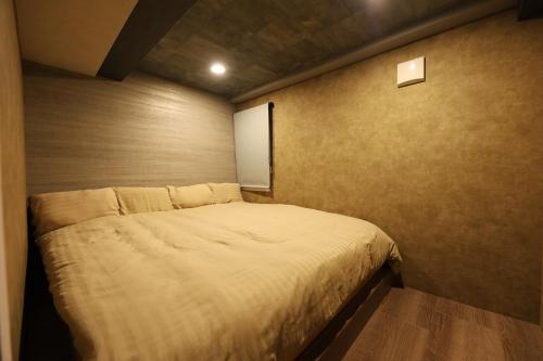 a small bedroom with a bed in the corner at Lions Mansion Sapporo Jozankeisanbankan 206 - Vacation STAY 17731 in Sapporo
