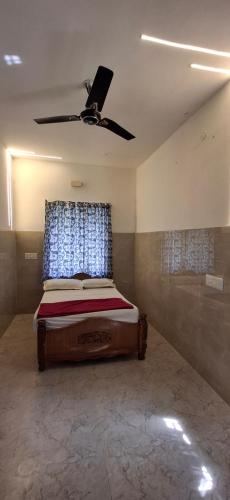 a bedroom with a bed with a ceiling fan at Bamboo Private Homestay Yercaud in Yercaud