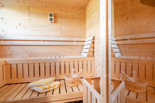 a wooden sauna with two beds and chairs at Gästehaus am Hahnenkamm in Reutte