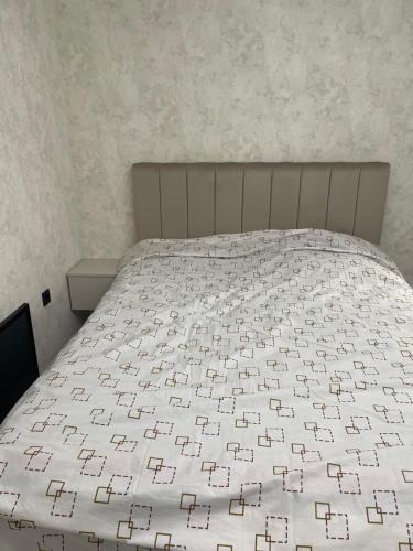 a bedroom with a bed with a white bedspread at VeneraHouse in Karakol