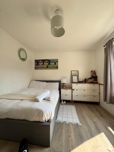 a bedroom with a bed and two dressers at Sunset View 2BR Apartment - Beautiful London View & Free Parking in London