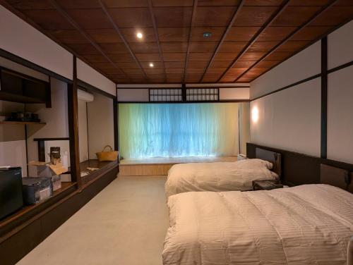 大津市にあるguesthouseKinari - Vacation STAY 99387vの大きな窓のある部屋にベッドが2つある