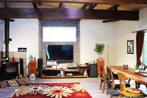 a living room with a table and a television at Guesthouse Nagomi in Minamiaso - Vacation STAY 17895 in Minami Aso