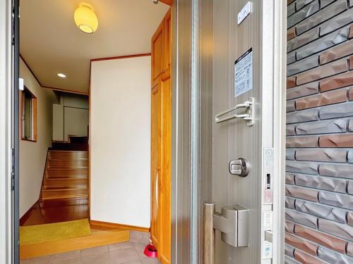 eine Tür, die in einen Flur mit Ziegelwand führt in der Unterkunft Wanoie - Vacation STAY 17705 in Osaka