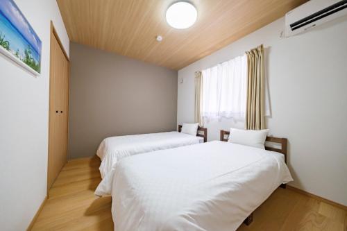 two beds in a room with a window at BLUESOLARE Reef - Vacation STAY 14140v in Miyako Island