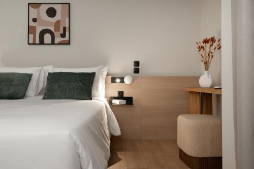 アテネにあるGnamma Hotelのベッドルーム(緑の枕が付く白いベッド付)