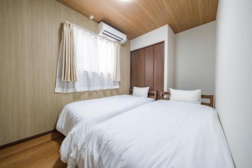 two beds in a small bedroom with a window at BLUESOLARE Aqua - Vacation STAY 14988v in Hirara